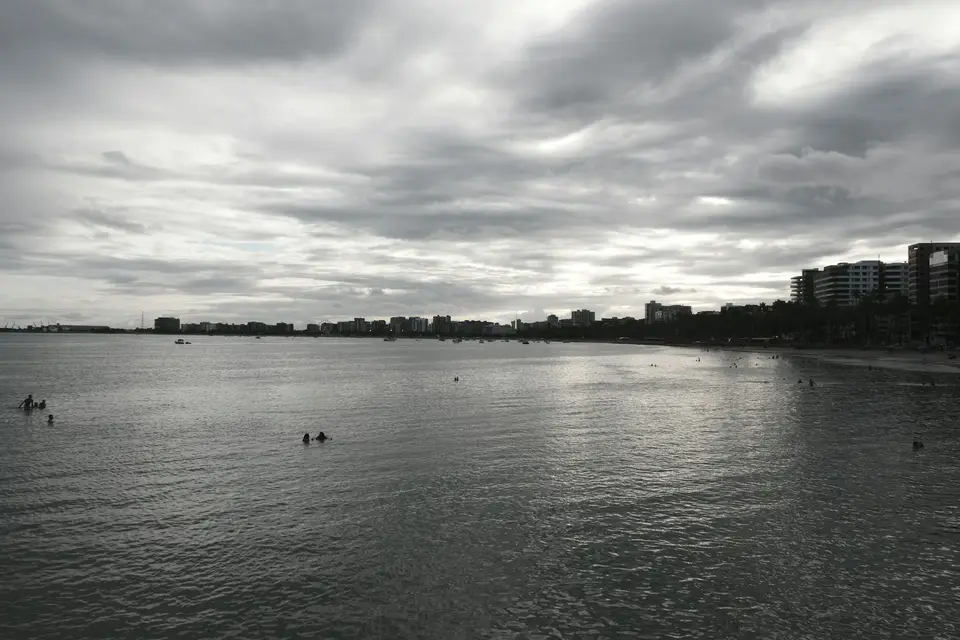 Cloudy sky over the ocean and distant city — Maceió