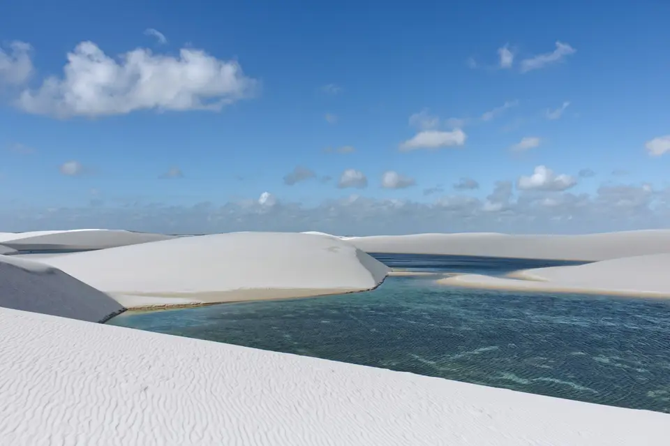 White sand dunes with blue water under cloudy sky — Maceió