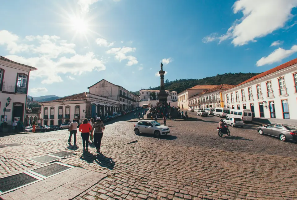 a group of people walking down a cobblestone street — Ouro Preto