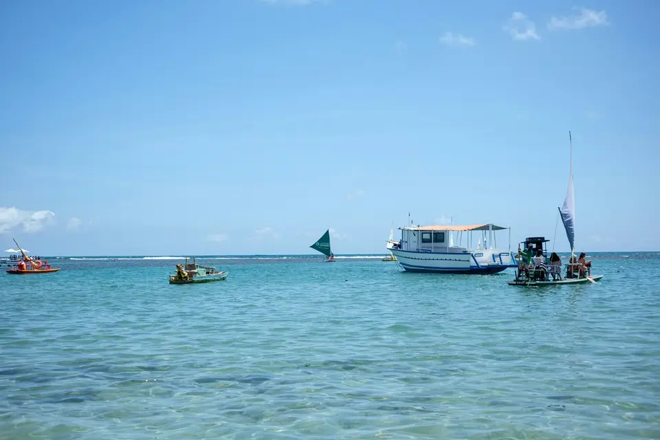 a group of boats floating on top of a large body of water — Porto de Galinhas